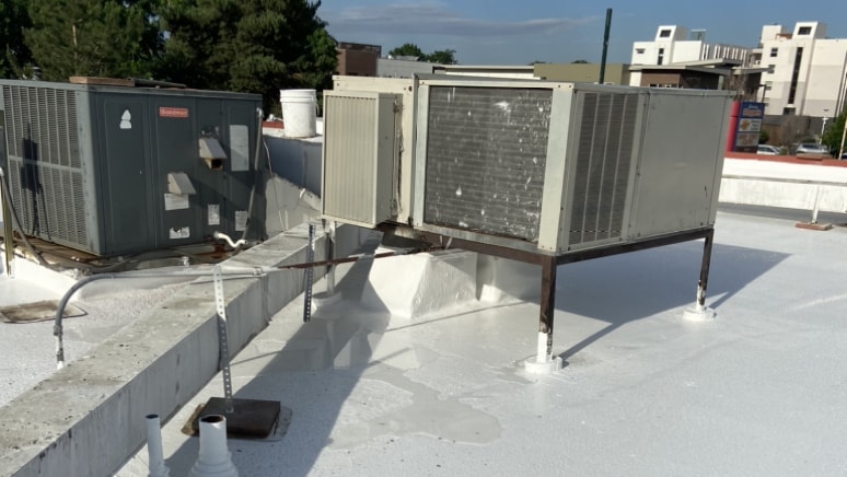 Commercial silicone roof coating in white by Metro City Roofing in Denver, Colorado with HVAC units on the roof